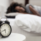 woman sleeping with alarm clock