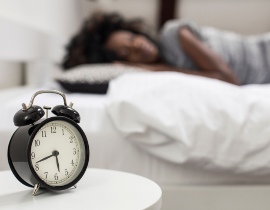 woman sleeping with alarm clock