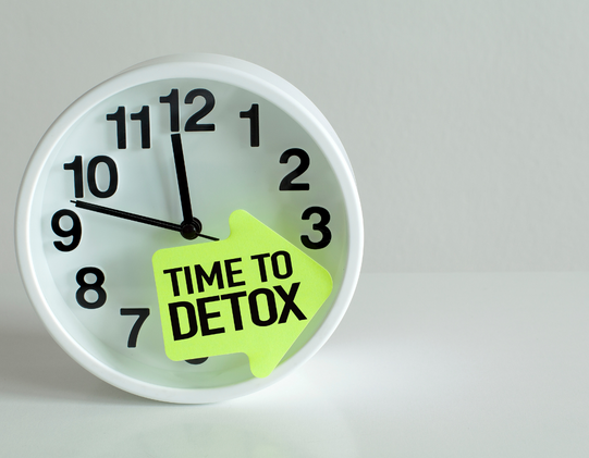 clock with sign that reads time to detox