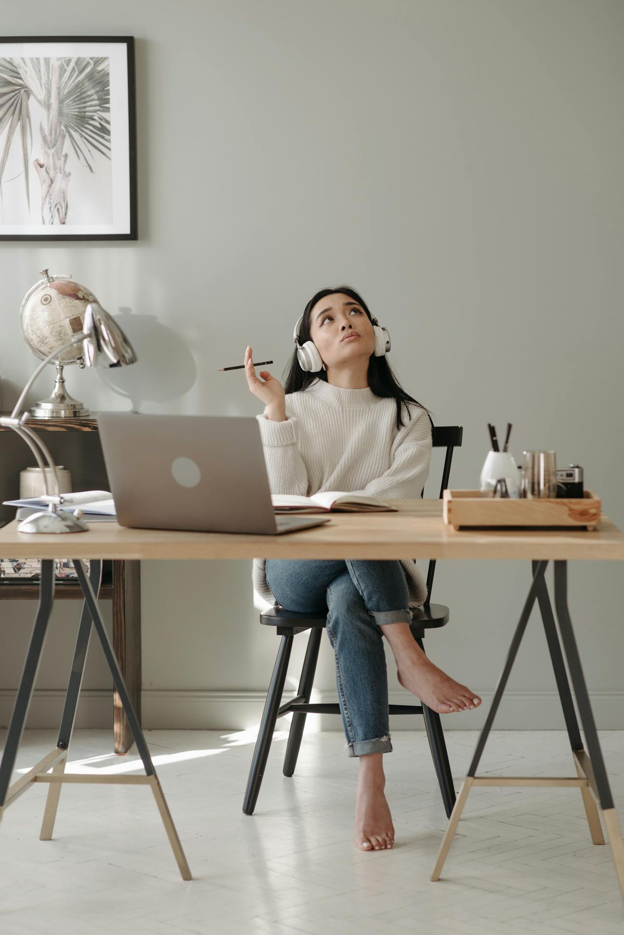 Woman studying at a laptop, looking distracted and tired in home office, representing brain fog and the search for the best brain supplements for adults.