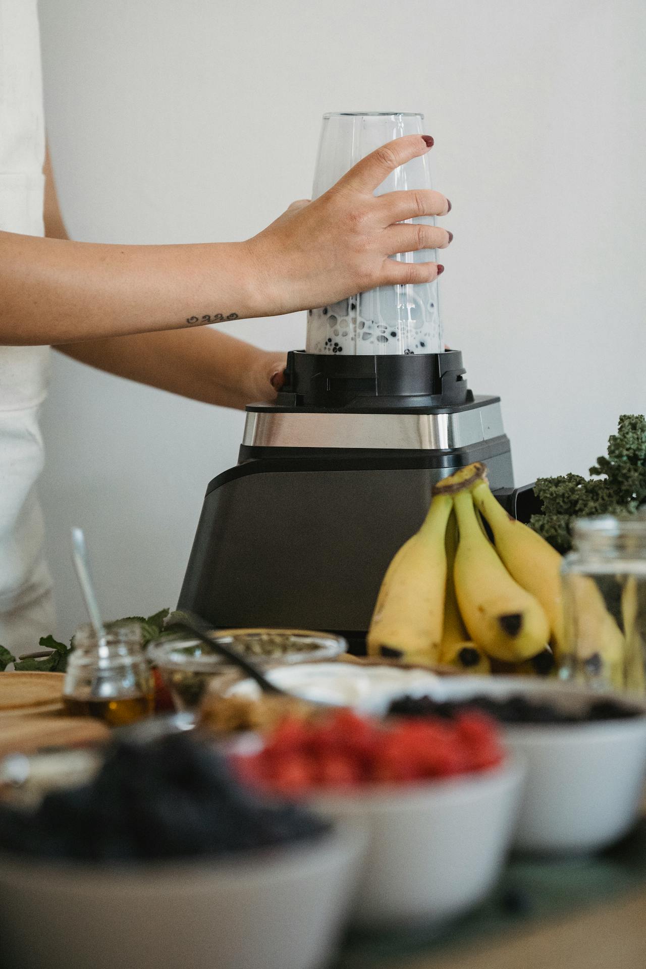 Preparing a fiber-rich smoothie with bananas, berries, and greens to support gut-brain axis health, digestion, and mental clarity.