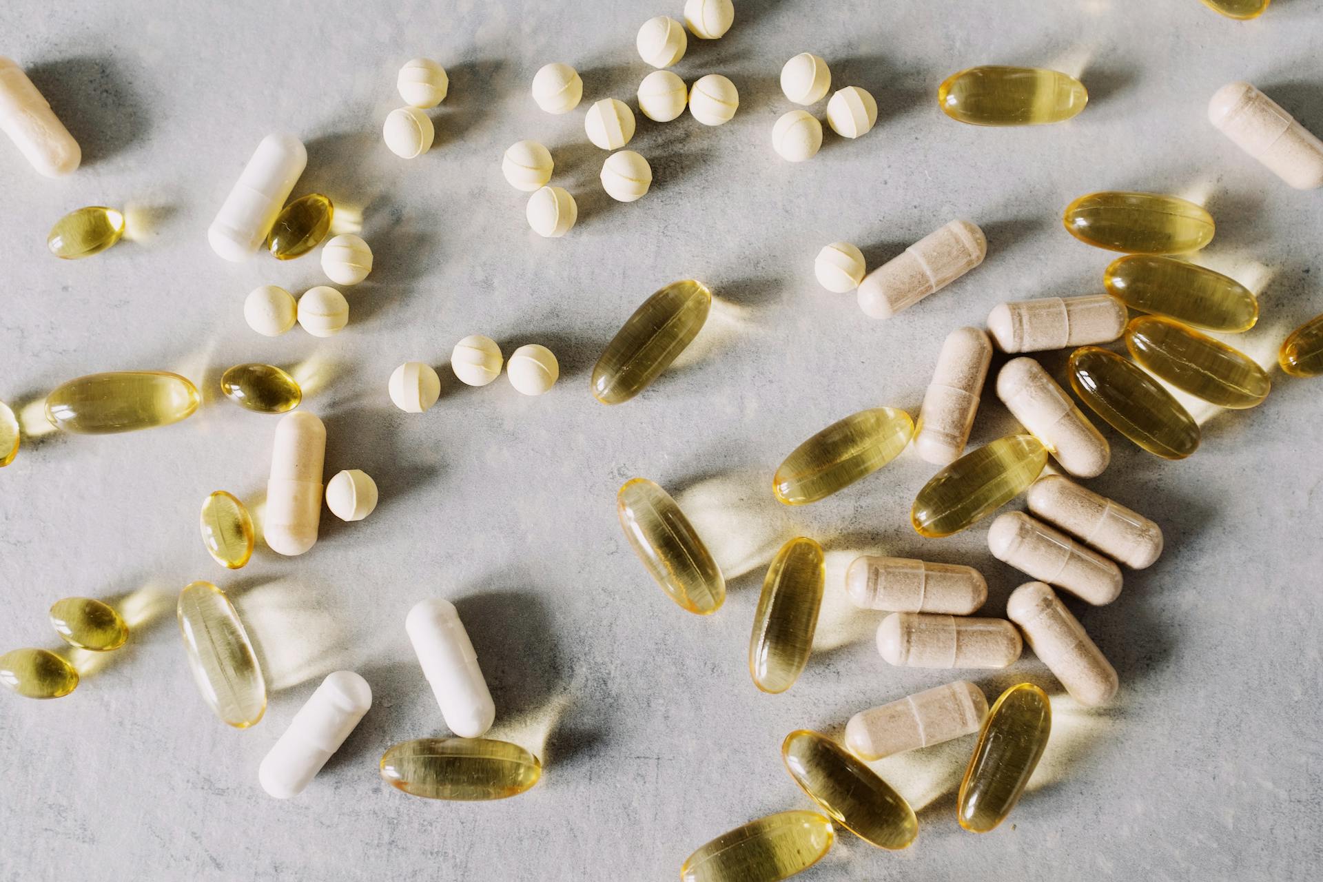Featured image showing mixed supplement capsules, tablets, and softgels scattered on a gray surface for an article about supplements you shouldn’t take together.