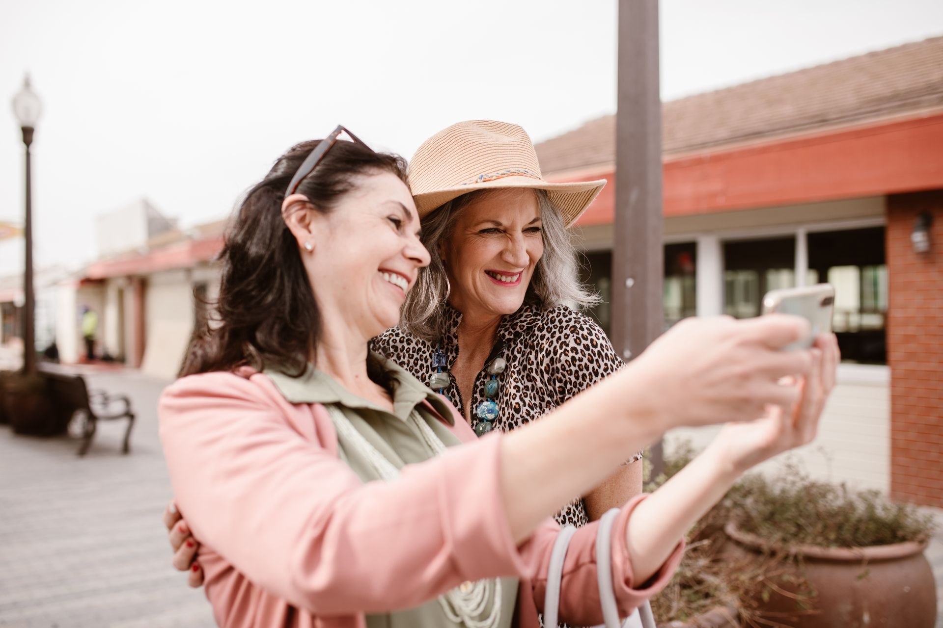 Two women smiling outdoors while taking a selfie for an article on perimenopause vs menopause supplements and stage-based health support.